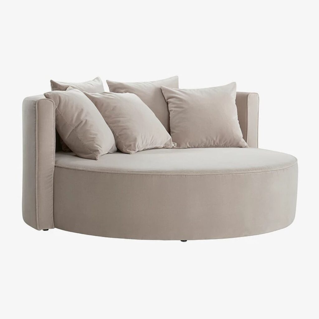 En rund beige soffa i mjuk design En rund beige soffa i mjuk design.